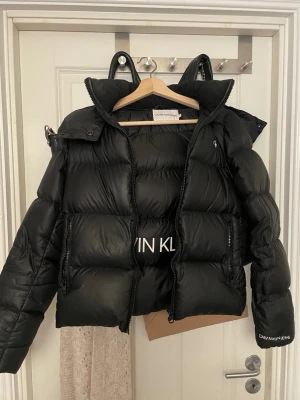 Svart pufferjacka från Calvin Klein - Snygg svart pufferjacka från Calvin Klein, liten defekt på märket framtil 💞