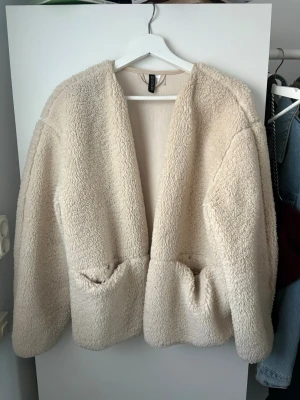 Beige teddyjacka från H&M - Mysig beige teddyjacka från H&M med två framfickor. 🐻 Köpte den i M då jag vela ha den lite oversized är annars S vanligtvis. Använd fåtal gånger, så bra skick☺️