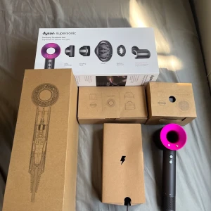 Dyson Supersonic hårfön fuchsia - Dyson Supersonic hårfön i färgen fuchsia och svart. Kommer med flera stylingmunstycken och originalförpackning. Hårfönen har en unik ringformad design och är tillverkad i plast och metall. Perfekt för snabb torkning och styling av alla hårtyper.