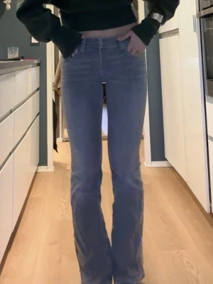 Grå bootcut jeans med stretch - Säljer ett par grå bootcut jeans med låg midja och stretchigt material. Jeansen har klassiska fem fickor och stängs med dragkedja och knapp. Perfekta för dig som gillar en bekväm men ändå snygg passform.💐💞