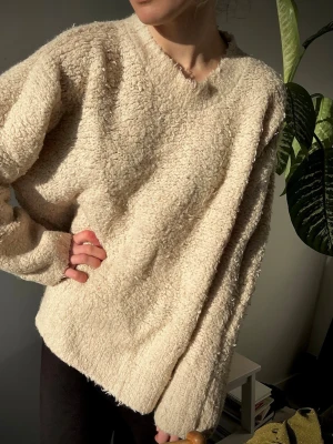 CARIN WESTER fluffig stickad tröja (S) - Mysig krämvit stickad tröja med fluffig, teddy-liknande struktur. Perfekt passform och långa ärmar. Från Carin Wester. Mycket gott skick.  Storlek S, men den är stor i modellen 