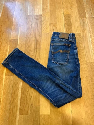 Mörkblå nudie jeans  - Tjena! Säljer dessa Nudie jeans. Modellen är Tube Tom. Storlek: W27, L32. Dom fraktas inom 24 timmar efter köp. Priset kan diskuteras. Vid minsta funderingar är det bara att skriva.