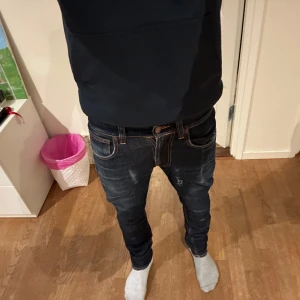 Nudie jeans mörkgrå - Säljer dessa mörkblå jeans med slitningar från nudie då den är för små för mig. Storleken på de är 27/32 och skulle passa någon som är ungefär 160-165. Skick 8/10. Öppen för byten också🤝. Hör av dig vid minsta fundering🙌