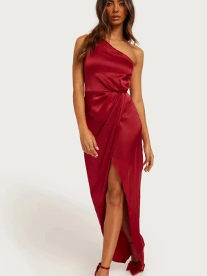 Röd oneshoulder långklänning i satin - Snygg röd långklänning i satin från Nelly  med oneshoulder-design och hög slits framtill. Klänningen har en draperad effekt vid midjan som ger en elegant siluett. Perfekt för dig som vill sticka ut med en stilren look. Till balen, bröllopsgästen eller festen! Endast använd 1 gång