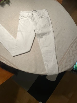 Vita slim jeans från Lindbergh - Snygga vita skinny jeans från Lindbergh med klassisk femficksdesign och silverfärgade nitar. Jeansen har normal midja och smal passform hela vägen. Stl 29/34 men passar dig som är ca 180-190 