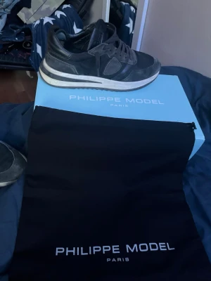 Philippe Model sneakers - Mörkblåa sneakers från Philippe Model Paris med klassisk låg siluett. Skorna har ovandel i mocka och läder, vita detaljer på sulan och svarta skosnören. Snygg och stilren design som passar till det mesta. Levereras med originalkartong och dustbag. Skriv vid minsta fundering🙌🏼