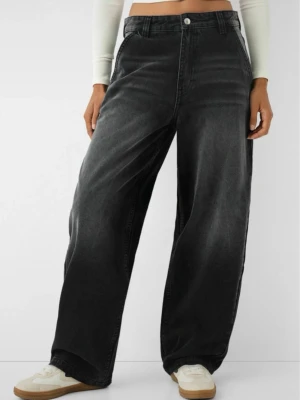 Svarta wide leg jeans från bershka  - Säljer ett par svarta wide leg jeans från bershka. Ser ut så på bilden att vara högmidja men sitter low waist. Jeansen är klippta längst ner pågrund av att dom är så långa. Använd en gång då dom är alldeles för stora i midjan för mig. Står storlek M men tycker de är mer år L.Tillverkade i tvättad denim som ger en cool vintagekänsla.