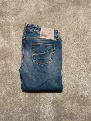 Jacob Choën - Snygga blå jeans från Jacob Cohën. Jeansen har en lätt tvättad look och detaljerade sömmar på bakfickan. Perfekta för en avslappnad stil och tillverkade i mjukt denimtyg.