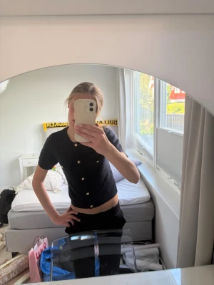 Marinblå  kortärmad topp med knappar. - Stickad, fin T-shirt med knappar.