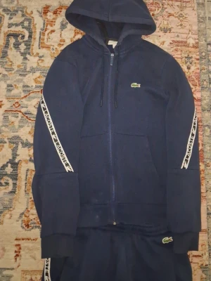 Mörkblå Hoodie Och Byxor Från Lacoste - Säljer min lacoste tracksuit byxorna m tröjan s skriv om ni har frågor.
