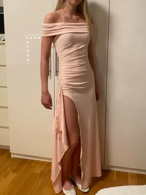 Ljusrosa offshoulder långklänning - Säljer min ljusrosa balklänning som är off shoulder och har hög slits på sidan.