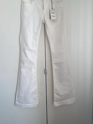 Vita skinnet flare jeans från Zara - Säljer ett par vita bootcut jeans från Zara. Jeansen har en snygg utsvängd passform.Dom är rätt så långa (jag är 167 cm)