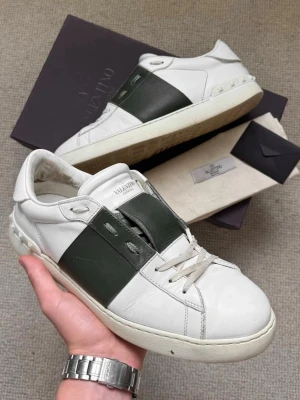 Valentino Garavani  - Valentino Garavani Rockstud i vit och mörkgrön rand. Storlek 43. Perfekta för dig som vill sticka ut med en exklusiv touch. Skriv gärna ifall du har några frågor, är öppen till att sänka priset