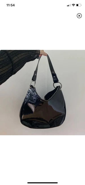 Väska - Rymlig väska i glansigt material från H&M. Kommer tyvärr inte till användning. 