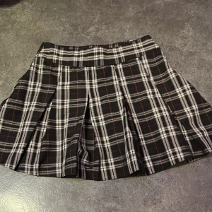 Rutig kjol  - Säljer denna kjol då ja inte använder den längre. Bra skick. Dragkedja på sidan