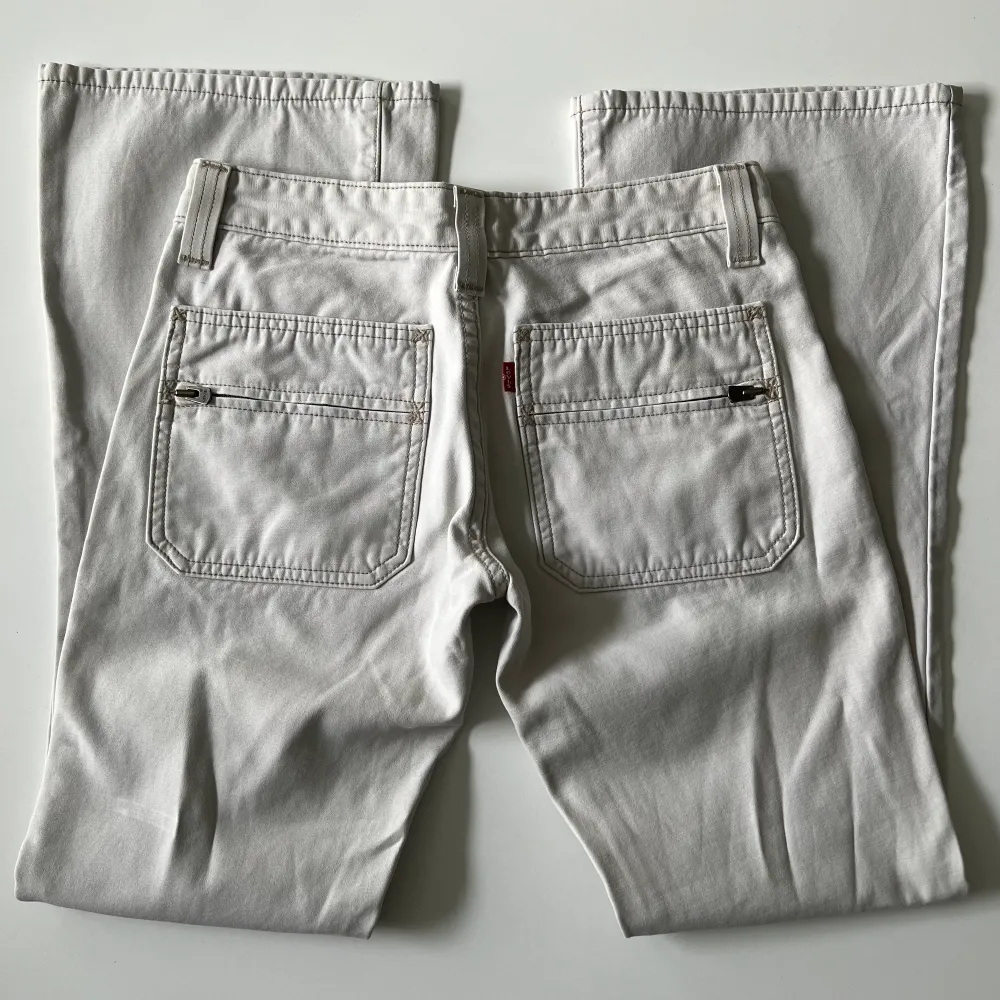 Vita / beiga lågmidjade bootcut jeans från Levi’s. Midjemått: 72 cm. Innerbenslängd: 75 cm. Hon på bilderna är 167 cm lång 💕. Jeans & Byxor.
