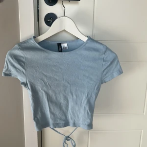 Gullig topp med öppen rygg💕 - Jätte gullig babyblå topp från hm i storlek Xs. Öppen rygg som man kan knyta Oanvänd, köpt för 3 månader sedan Nypris var ca 99kr💕💕
