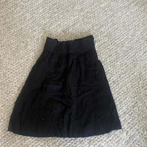 Svart kjol - Svart kjol med en roset där bak!