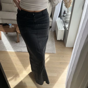 Kjol - Kjol i jeans material. Lång och har en slit där bak. Svart/grå tvätt med fickor jag är 172cm