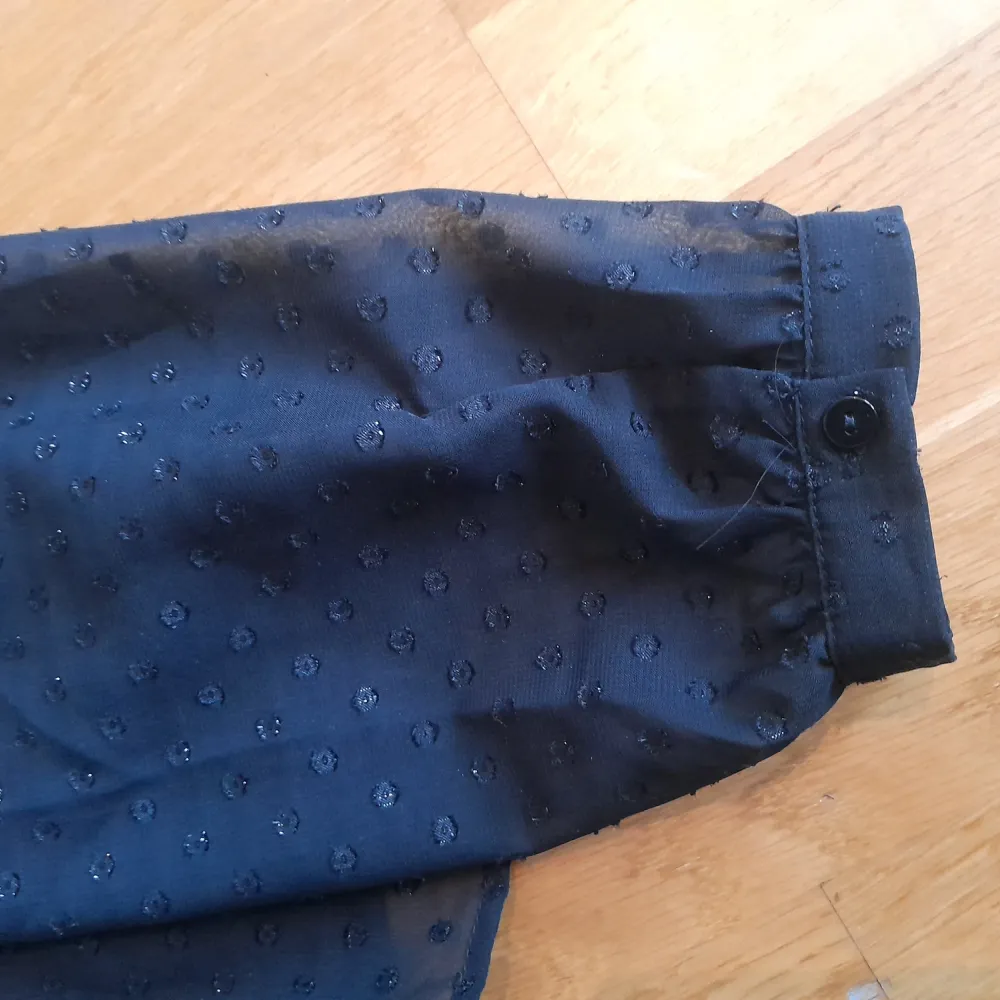 En svart fin blus med prickar som tyvärr inte kommer till användning då den är lite för stor för mig, bra skick, lite genomskinlig.. Blusar.
