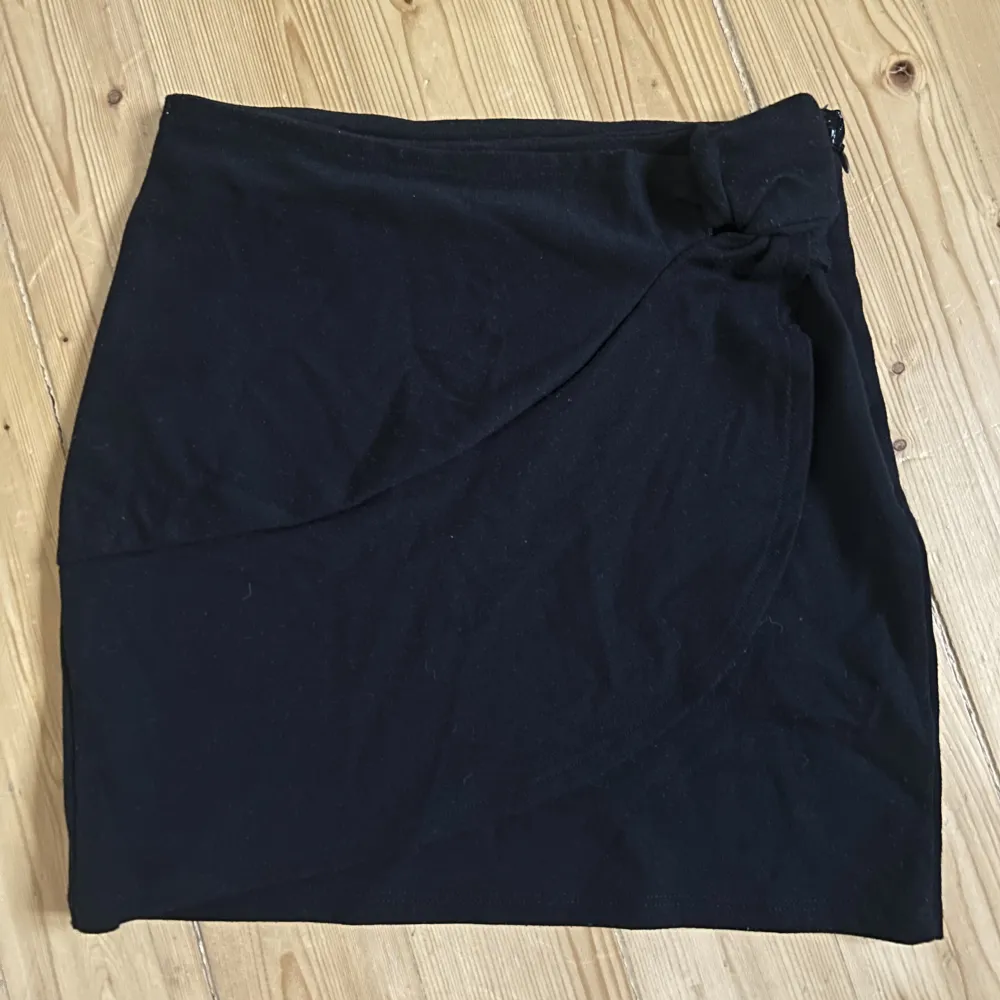 En svart kort kjol från only med en knut på högra sidan. Står att den är XS men skulle säga att den är XXS. Har använt en eller två gånger endast.. Kjolar.