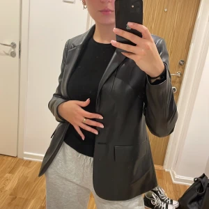 Kavaj i pu läder - Säljer min kavaj från Mango pga för liten. Knappen har trillat av men man kan enkelt sy dit en stor svart knapp om man vill det. Annars är det inget som syns. Rak i modellen men inte för oversize