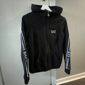 ea7 zip hoodie - den är i fint skick, inte urtvättad eller så! säljes då den är lite för liten åt mig, skicka för fler bilder