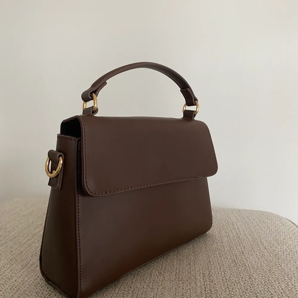 Säljer denna handväska i en nyans av brun. Ett större fack och två mindre. Frakt tillkommer💕. Väskor.