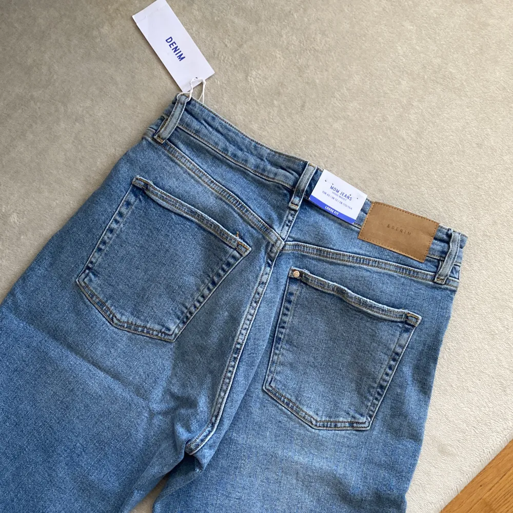 NWT. Ljusblåa jeans från H&M. Mom jeans, high waist & loose fit. . Jeans & Byxor.