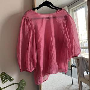 Rosa transparent blus med trekvarts ballongärm. I fint begagnat skick utan anmärkningar. Fin nu till sommaren. Uppskattad storlek är M, men passar även större och mindre beroende på hur man vill att den ska sitta. 