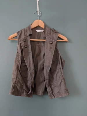 Väst - Snygg gröngrå väst. Jag på bilden är strl S/M. Hör av dig om du har frågor 🥰