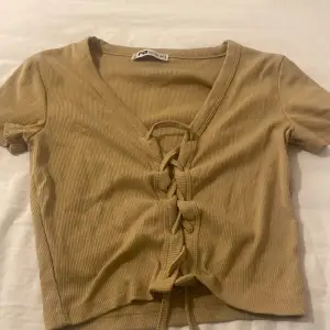 Beige/brun tröja med snören som man kan knyta längst ner  Från new yorker 