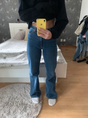 Jeans från Monki - Säljer mina högmidjade jeans från Monki i storleken 26. De är vida i modellen. På sista bilden visas slitage längst ner på byxorna. Detta går enkelt att klippa bort för att få fransigare. Längden blir också perfekt om man är kortare än 164 cm. 