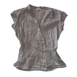 Blus med snöre - Grå blus med fina detaljer, knappar och snöre man kan knyta runt midjan 