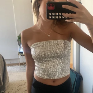 bandeau topp - Säljer min super fina glittriga bandeau topp som tyvärr aldrig har kommit till användning, perfekt för fester eller middagar. Köpte för 250kr och säljer för 150kr+frakt😊💓 Tryck inte på köp nu!