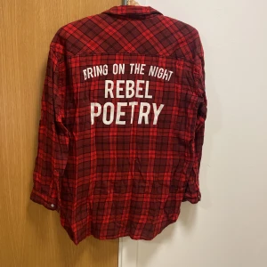 Tunn flanell skjorta  - Tunn röd/svart rutig flanell skjorta med text på ryggen från Gina Tricot. Stl 38. Jätte snygg! Använd några ggr. Säljer pga inte min stil längre. ❤️ 