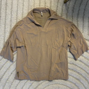 Tröja med krage  - En kortärmad tröja med krage. Armarna och modellen sitter lite löst. Från Only storlek M