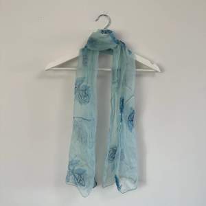 Blå mönstrad scarf i tunt material. 
