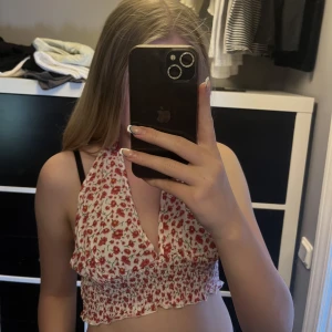 Blomming topp - Röd och vit blommig topp. Knytning där bak så den går att justera och knyta på olika sätt. Aldrig använd. Köparen står för frakten💗💗