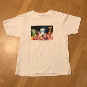 T-shirt med tryck - Skitskön tröja med  Alice i underlandet tryck! Köpt på Uniqlo för ett antal år sedan , säljer för den tyvärr blivit lite liten. Kontakta vid frågor eller intresse!