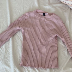 Rosa långarmad  - Inte så stretchig. Färgen är en varm rosa och tröjan är ribbad och slutet av armarna och vid magen så är det mönster (se bild :))  inga hål eller fläckar, väldigt mjuk och noppar inte. 