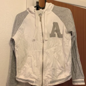 Vit huvtröja  - En vit huvtröja med gråa armar 