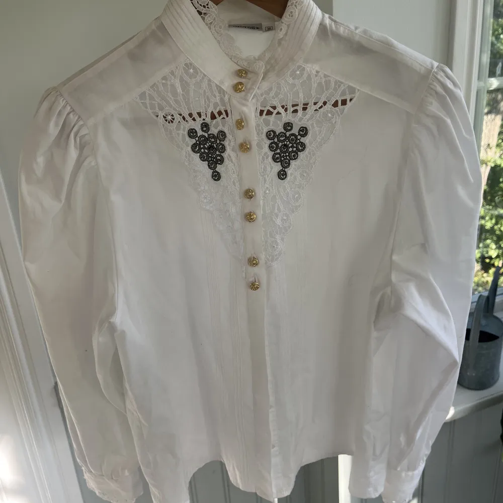 En vit lyxig skjorta med guld knappar och spets. Skjortan är från Grätz i stl 38 och har puff armar . Skjortor.