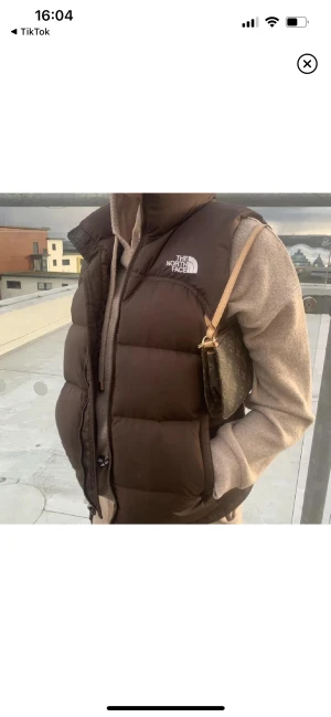 Brun north face väst - Intressekoll på min äkta bruna north face väst💗 inte lätt att få tag på, storlek M men passar mig som brukar ha S också! Köpt för ca 2000kr 2020💘 lånad första bild