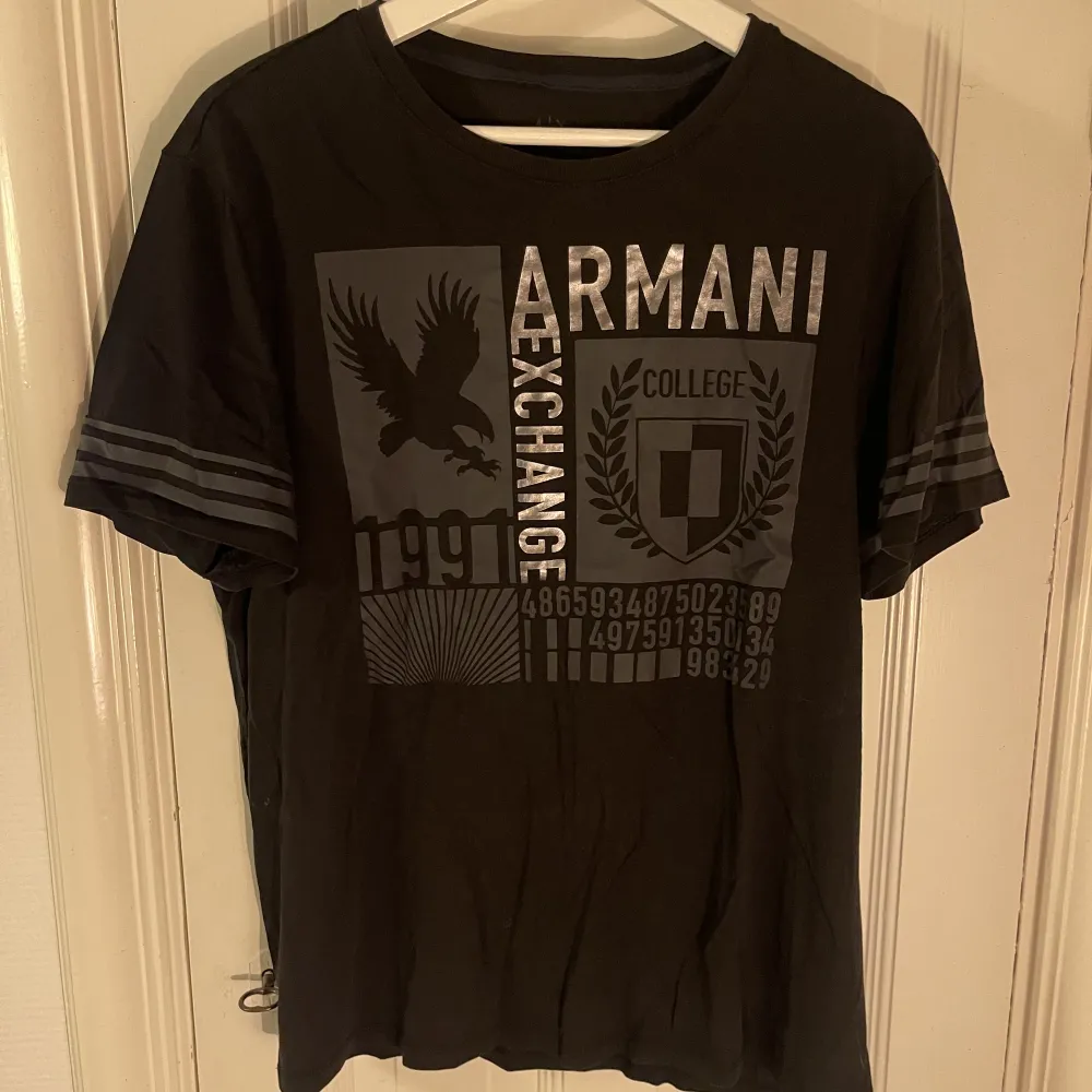 Svart t-shirt från Armani Exchange med stort tryck i silver och grått på framsidan. Storlek M, fint skick!. T-shirts.