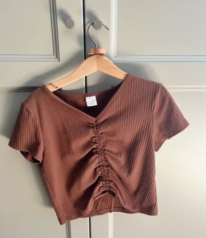 ruched brun topp från lindex  - använd flera gånger, inga defekter 🤍 säljer pga att den är för liten 🩷🩷 den är mer mjölk choklad brun irl, men den ser typ orange ut på bilden 💕