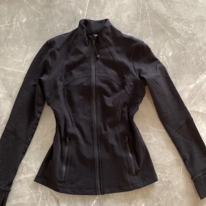 Lulu lemon define jacket - Säljer denna jätte populära define jacket i storlek 8 vilket motsvarar 36 JÄTTE fin passform men tyvärr för stor för mig MÖTAS ELLER FRAKTAS ORG PRIS 1300kr ett pytte litet hål som har SYTS igen vid baksidan men det är inget men märker av