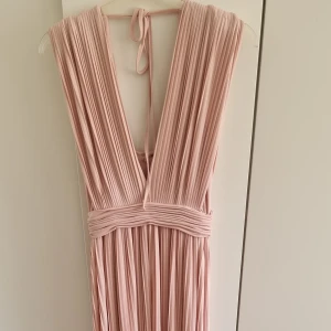 Tjock plisserad ljusrosa långklänning - Plisserad ljusrosa långklänning i fint tjockt material. Från Asos, storlek 38. Endast använd 1 gång
