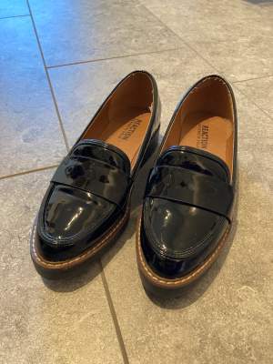 Black patent loafers, Kenneth Cole in size 36. Worn 5 times and with a small defect on the inside on one side, not visible when worn and does not bother when wearing