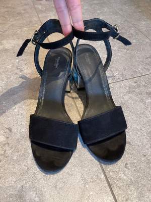 Sandals with 7 cm heel. The fabric is black velvet and the heel is silver, giving it a touch of shine, they tie at the ankle and are very comfortable. They are clean with no defects